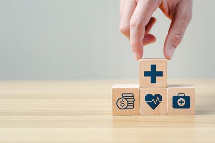 Foto: Hand legt einen Holzblock auf andere Blöcke