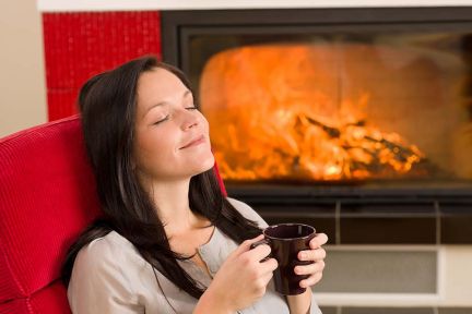 Foto: Frau vor Kamin